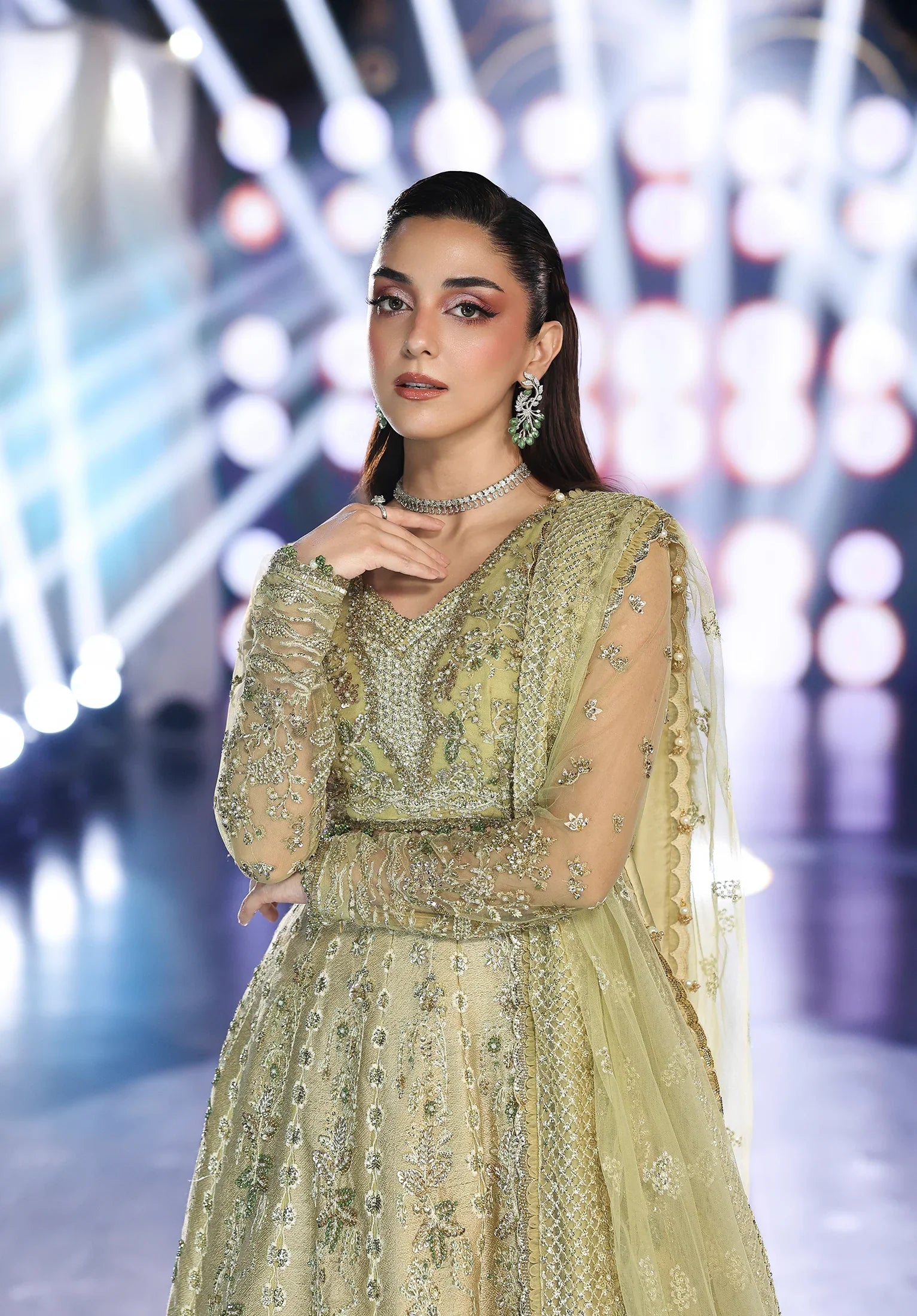 Woman in a green embroidered outfit with a blurred background
