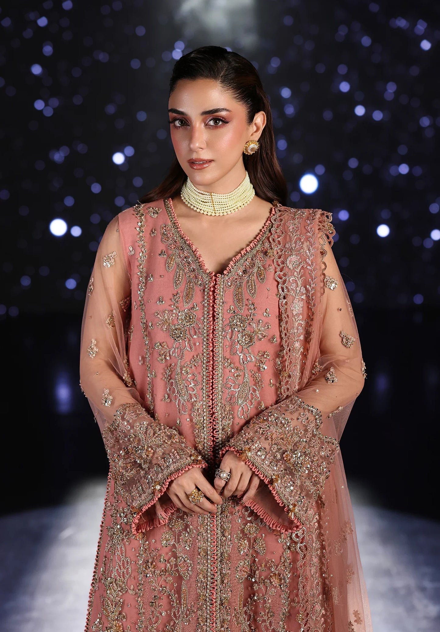 Woman wearing a pink embroidered traditional outfit with Elaf Stardom Handwork.