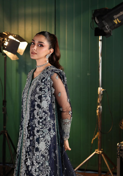 Woman in an embroidered outfit standing in a studio with green screen background