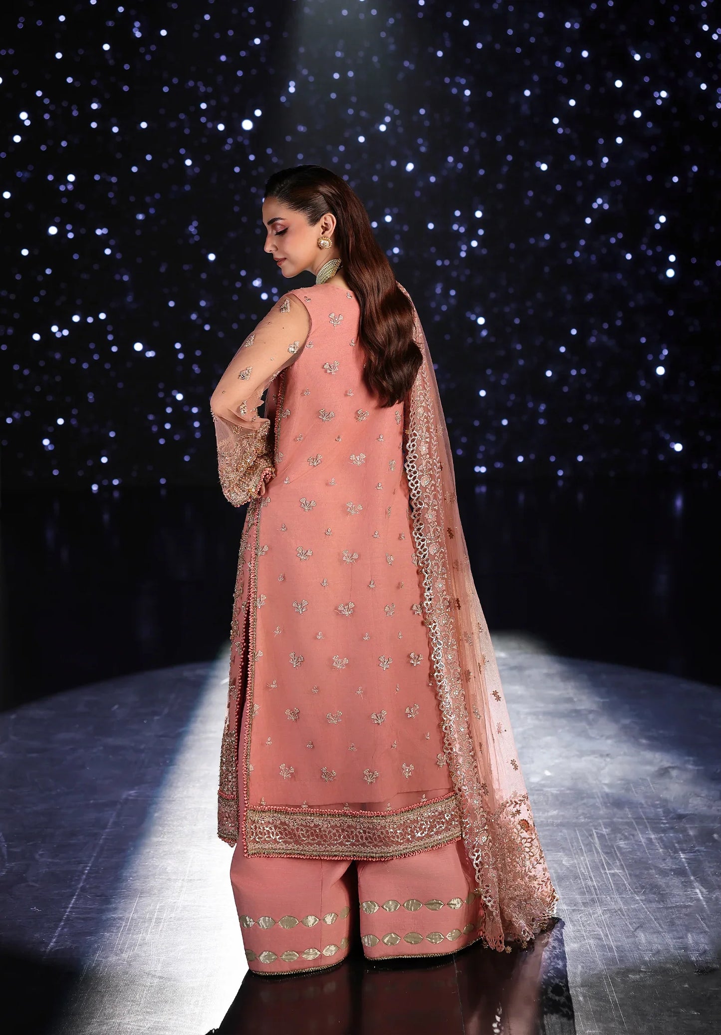 Woman in a peach traditional outfit with Elaf Stardom Handwork.