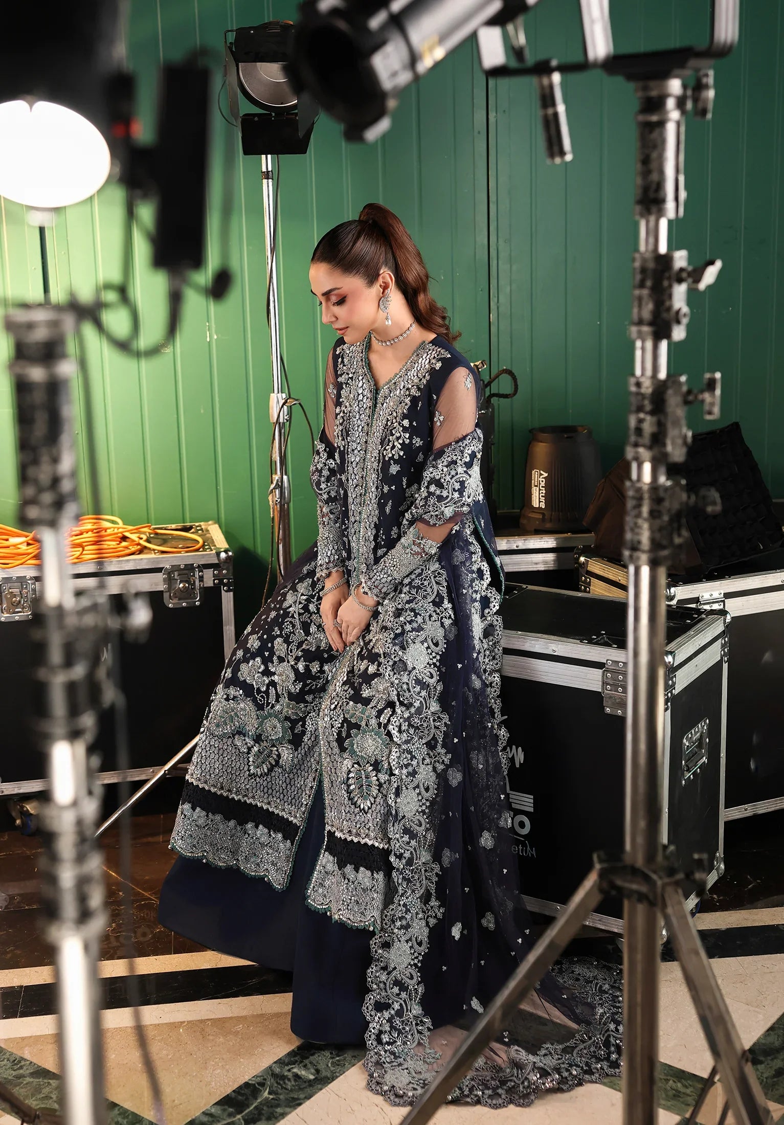 Person in a detailed traditional outfit standing behind film camera from ELAF STARDOM - FORMAL HANDWORK '25
