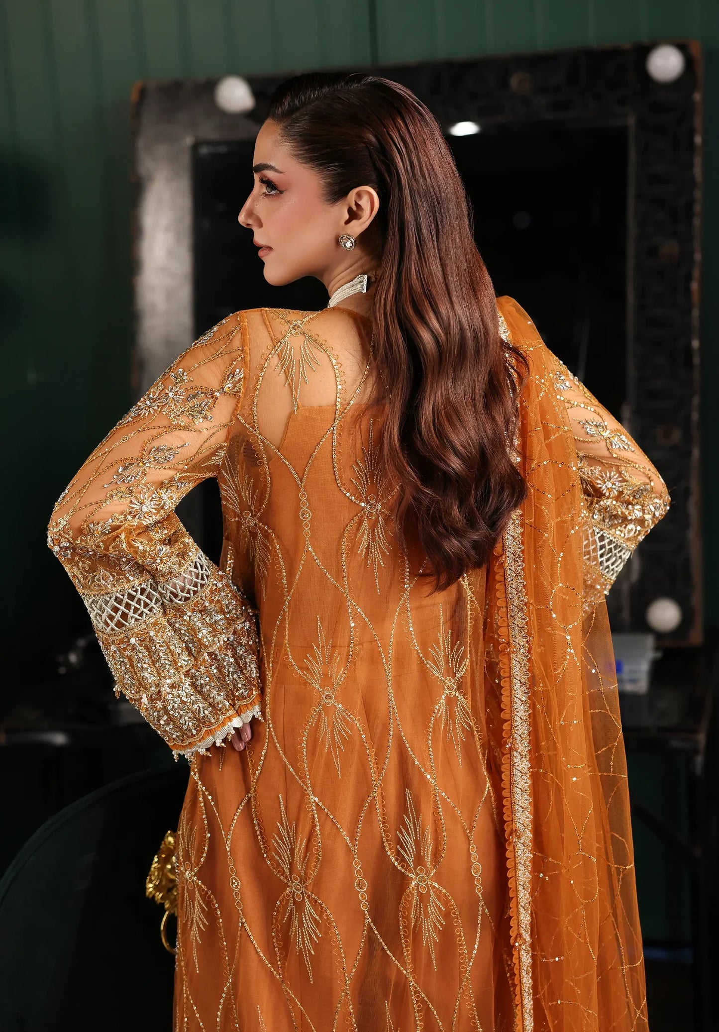 Woman wearing a mustard yellow embroidered outfit with a blurred background