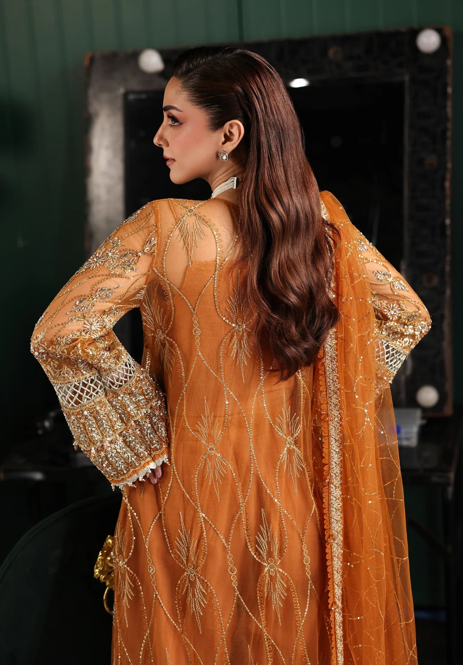 Woman wearing a mustard yellow embroidered outfit with a blurred background